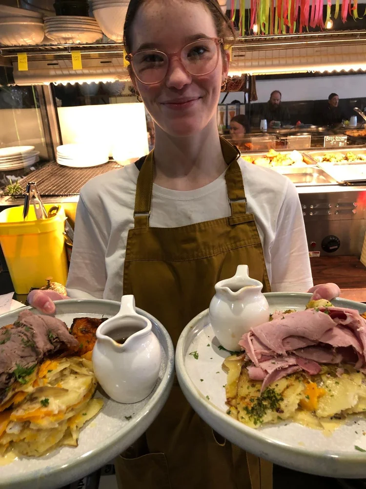 A Kokodeli team member holding two meals